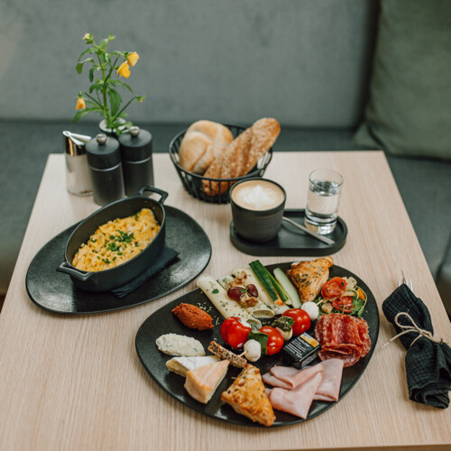 Frühstücksteller mit Rührei, Käse, Schinken und Gemüse im Kaffeehaus in Salzburg