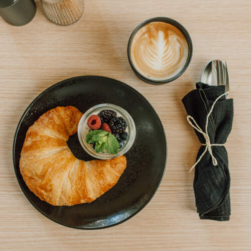 Croissant mit Beeren und Cappuccino zum Frühstück in Salzburg